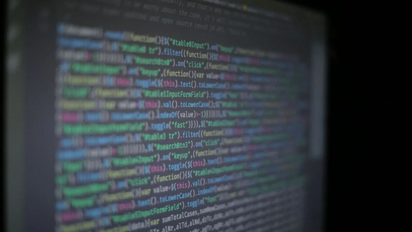 Close-up of colorful programming code on a blurred computer monitor